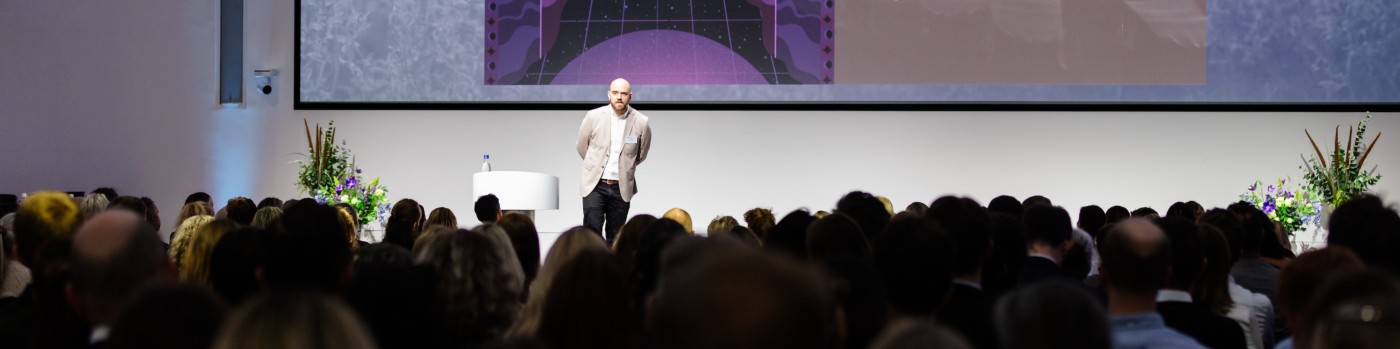 Jonas G. Mikkelsen speaking on stage